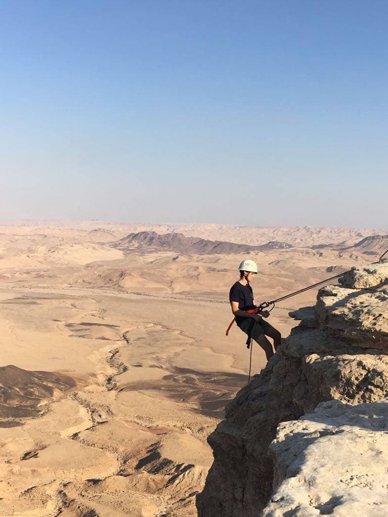 Abseiling down a desert canyon
